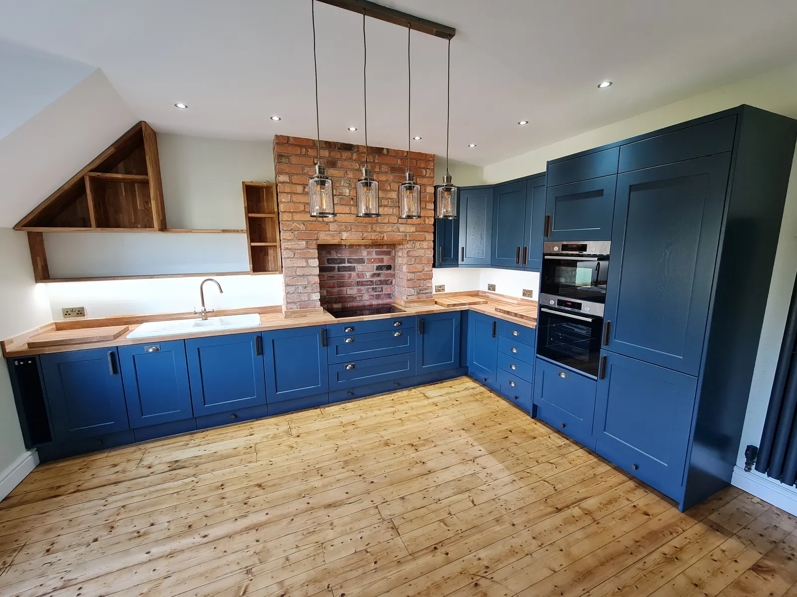 Completed blue kitchen renovation by Home & Gardens NW with fitted cabinetry and finished worktops