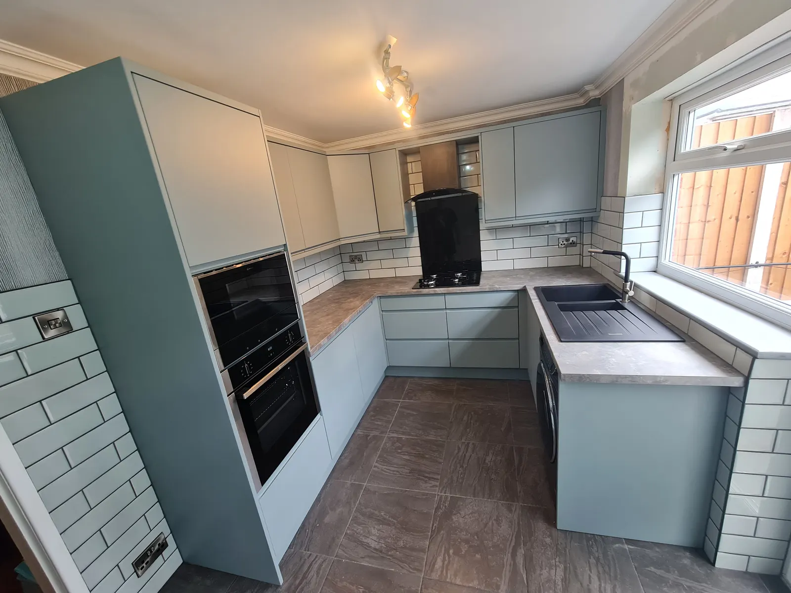 Pale blue fitted kitchen cabinetry in a completed home renovation