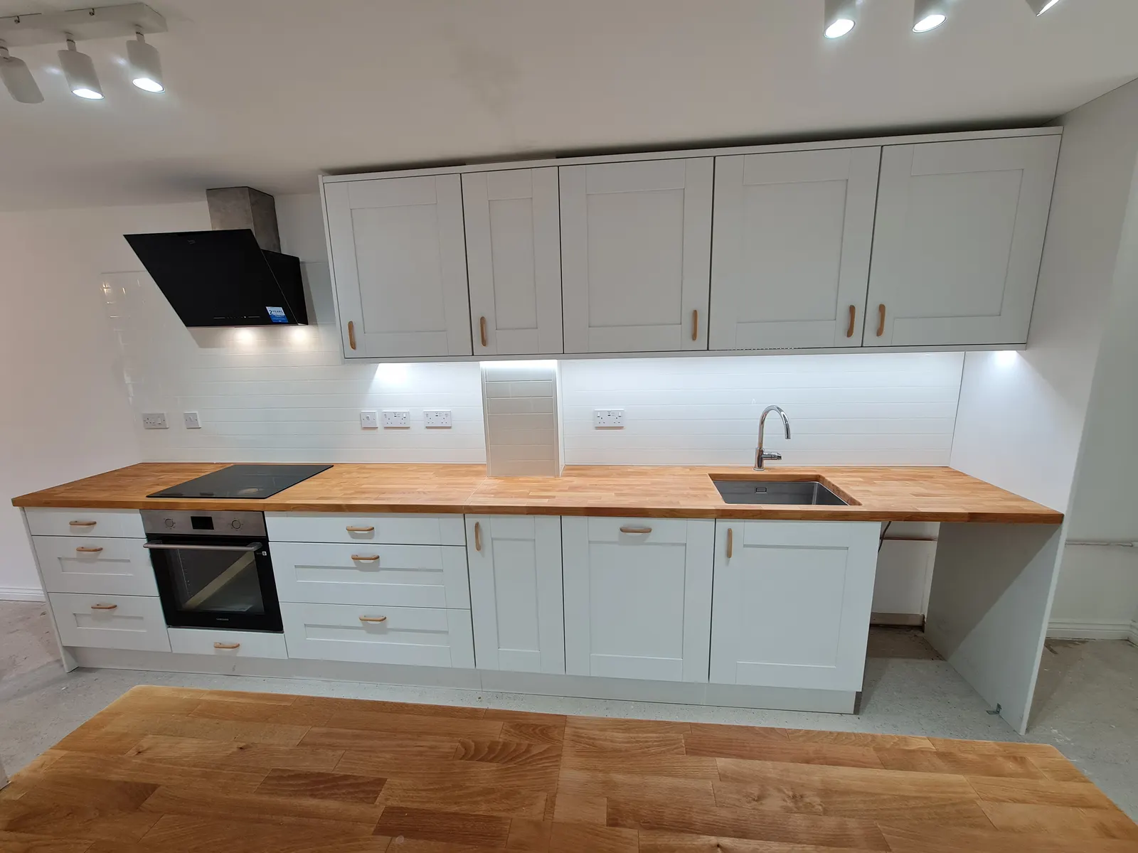 Wide view of a bright white fitted kitchen completed by Home & Gardens NW